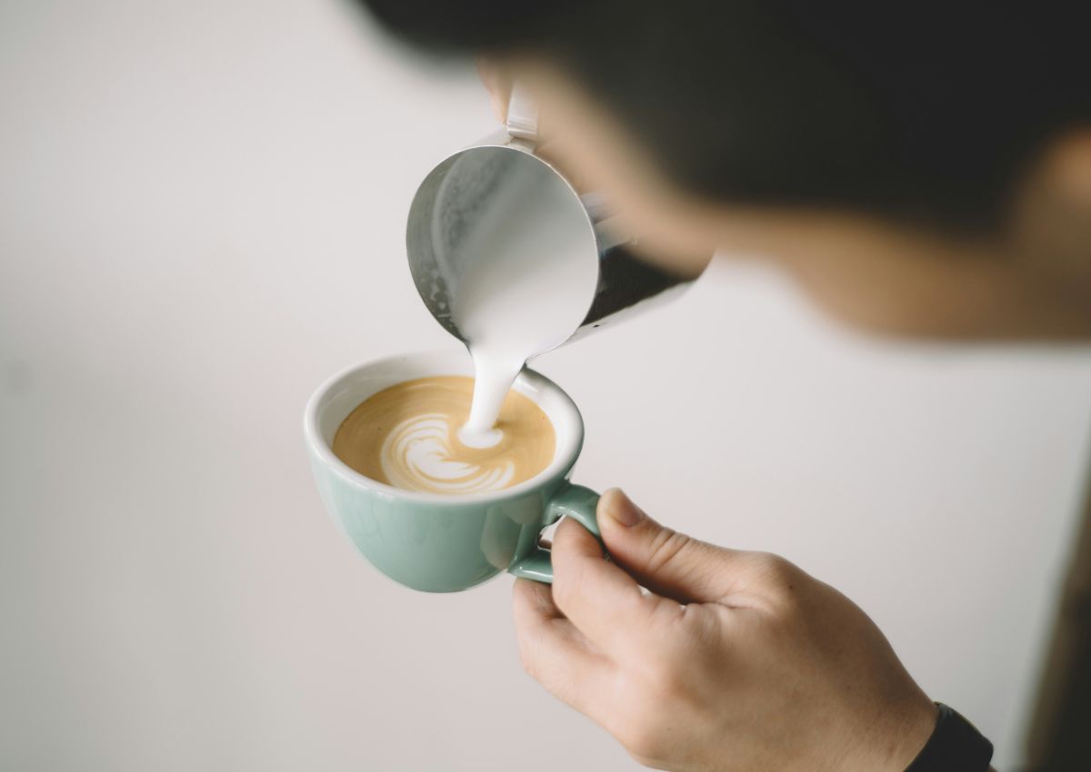 Milchschaum wird in eine Cappuccino-Tasse gegossen