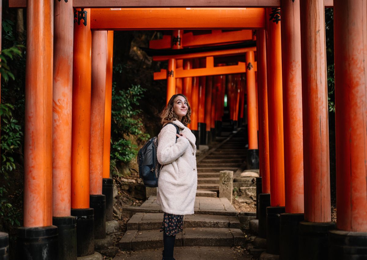 Frau zwischen den Torii-Toren am Fushimi-Inari-Schrein in Kyoto