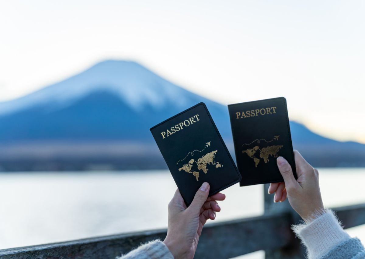 Frau hält vor dem Mt. Fuji ihren Reisepass in den Händen