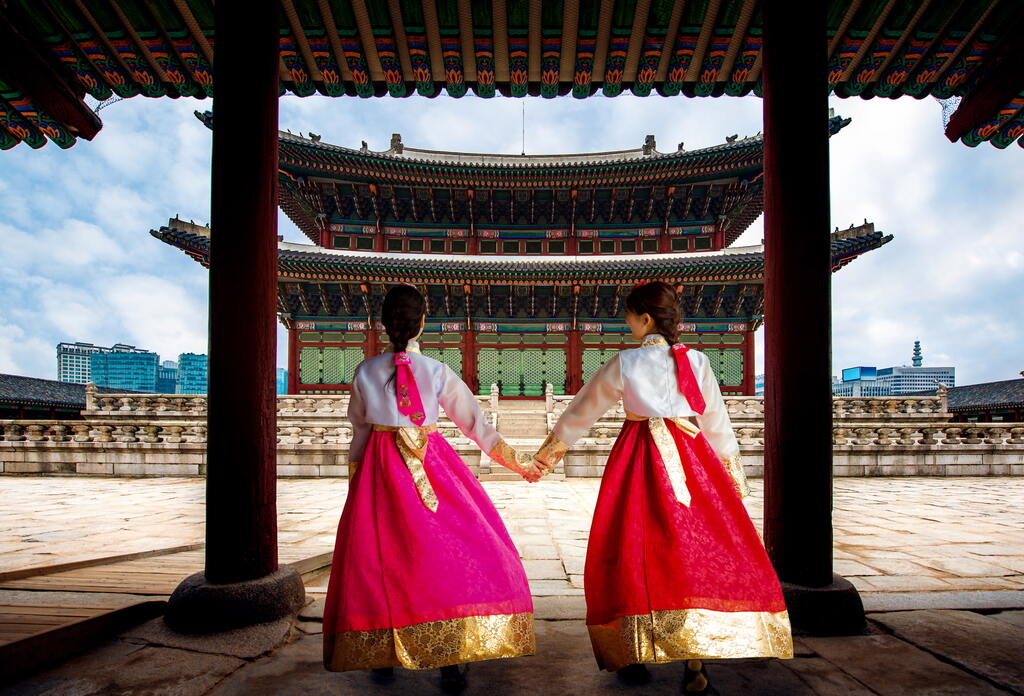 Traditionell im Hanbok gekleidete Besucher erkunden den Gyeongbokgung-Palast, das historische Herz Seouls