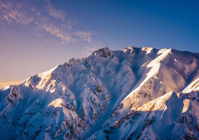 Sonnenuntergang über der winterlichen Gebirgskette von Hakuba, Japan