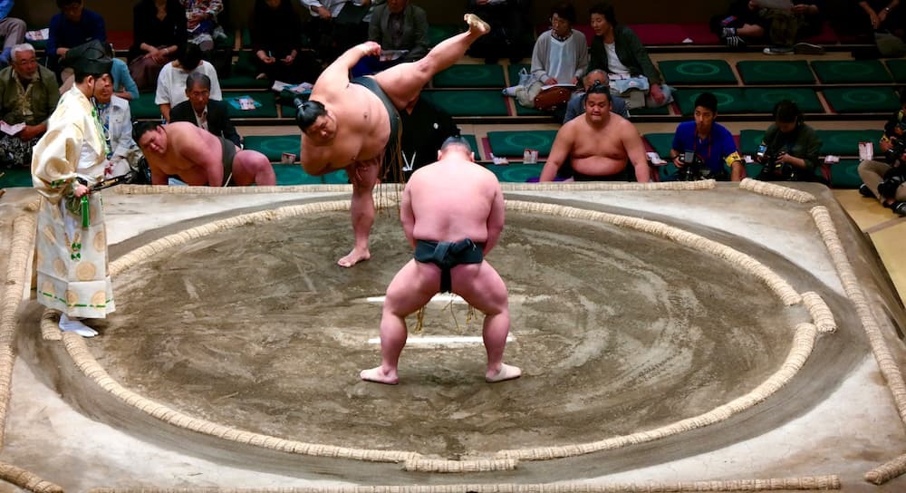 Japanische Sumo-Ringer, die sich im Ring auf einen Kampf vorbereiten und den traditionellen Mawashi tragen
