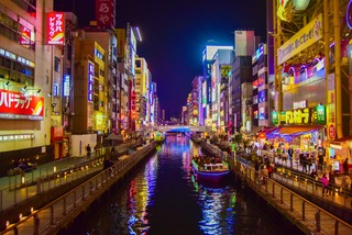 Neonlichter und Streetfood prägen die lebhafte Atmosphäre von Dotonbori am Abend. 